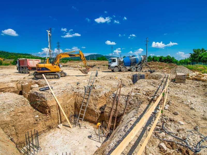 Excavation and foundation work at a construction site illustrating structural engineering strategies for building on expansive soils.