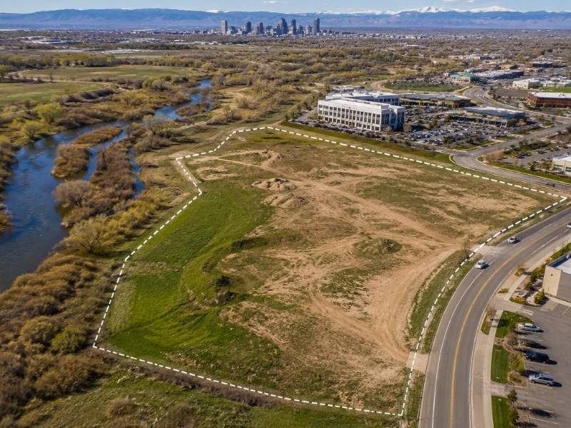 Aerial view of a commercial development site near a river showing potential floodplain areas evaluated during a flood study in Denver, CO.